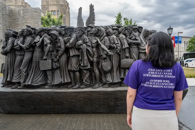 Elsy Pineda gazes at the Angels Unawares sculpture, a bronze sculpture of migrants and refugees from various lands crowded on a 20-foot boat at the Catholic University of America in Washington, D.C.